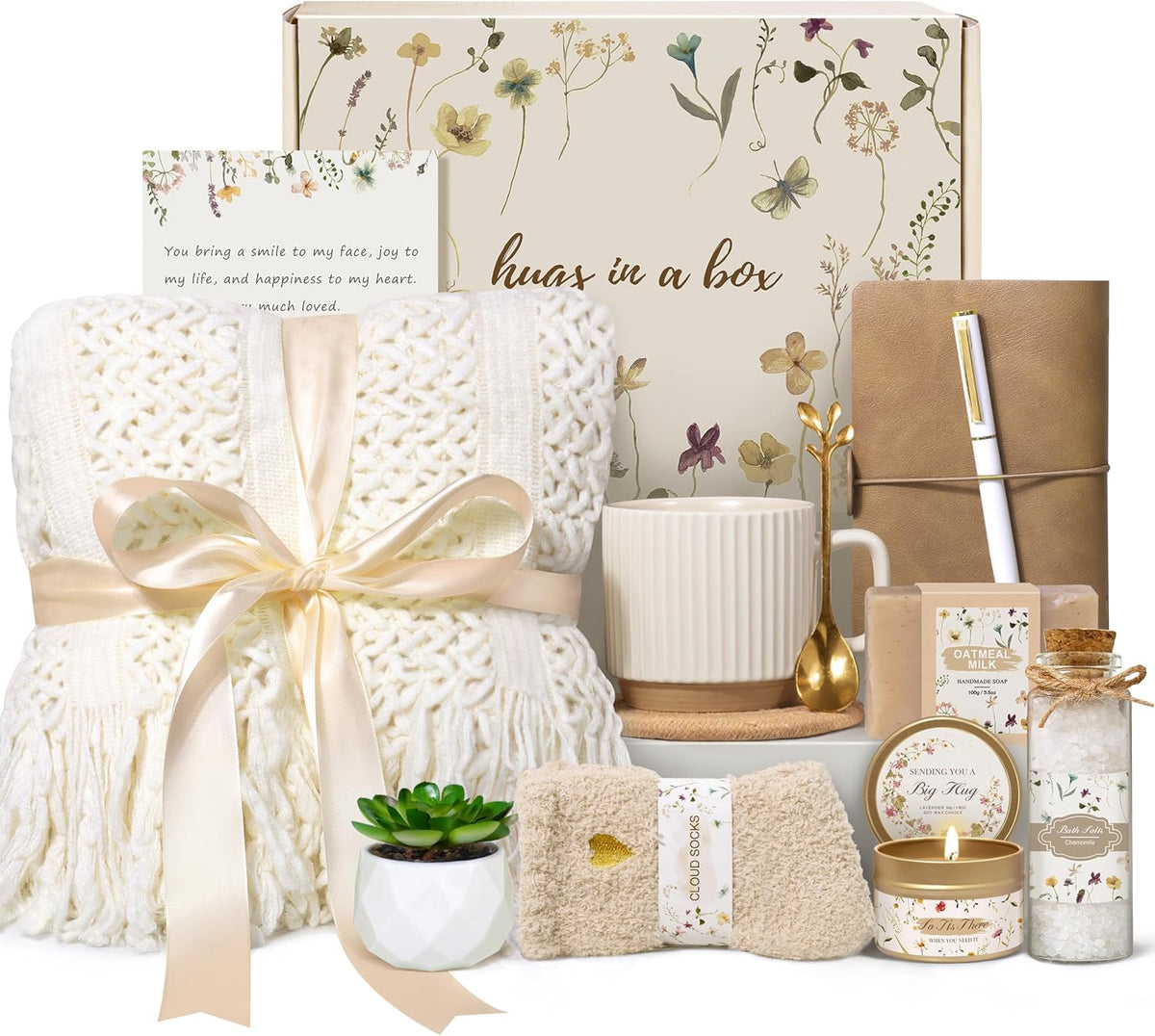 11-piece self-care set containing a blanket, mug set, candle, bath salt, soap, socks, plant, notebook, pen, greeting card, and gift packaging