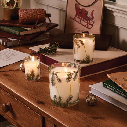 round white glass jar featuring a pine needle motif and decorative bow